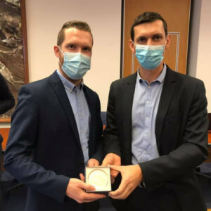 deux hommes avec un masque reçoivent une médaille